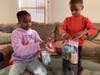 Jack and Jill of Westchester children Ava and Logan preparing individual 
food packages.
