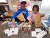  Jack and Jill-Westchester children Israel and Elle preparing 
 packages of soup and hot chocolate.
