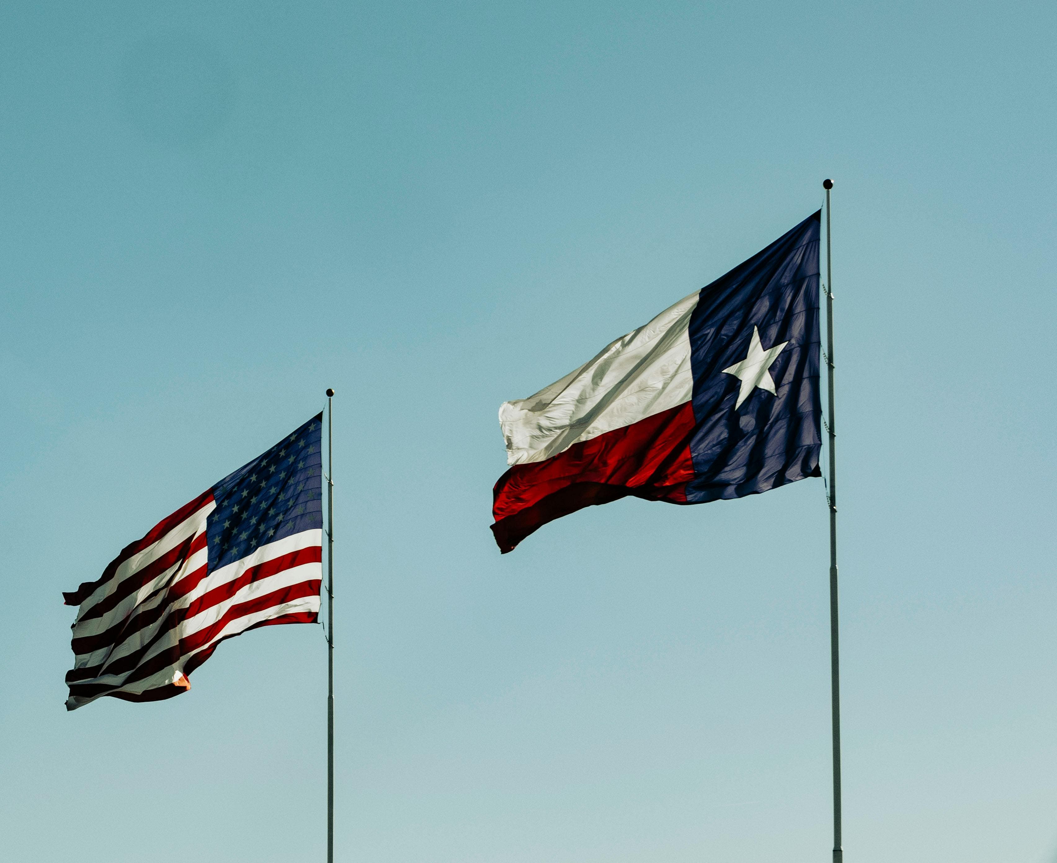 American flag and flag of Texas under the blue sky