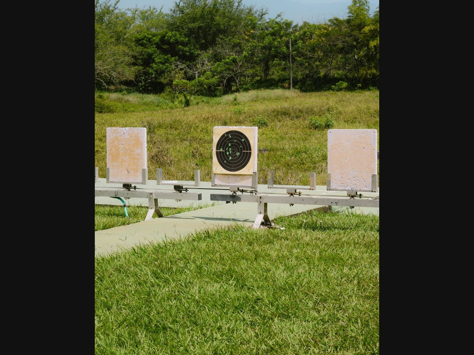 Outdoor shooting range with multiple target boards on a grassy field
