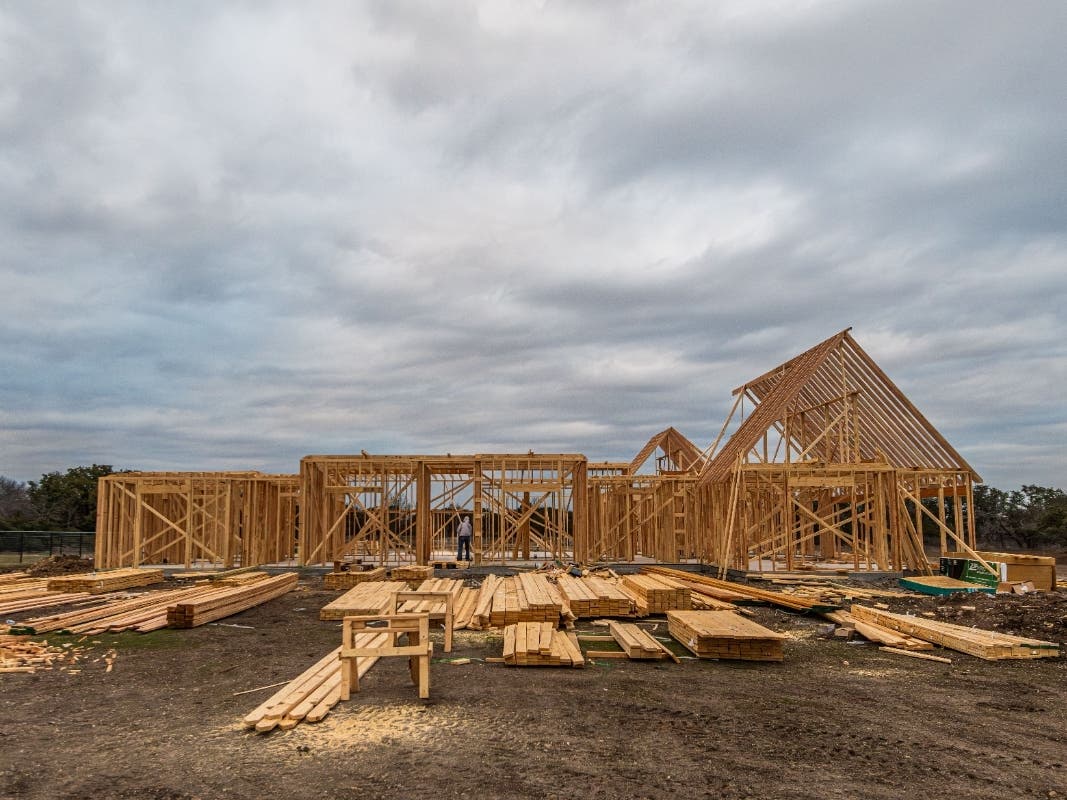 Wooden house framing under construction in Fort Worth, TX during a cloudy day.