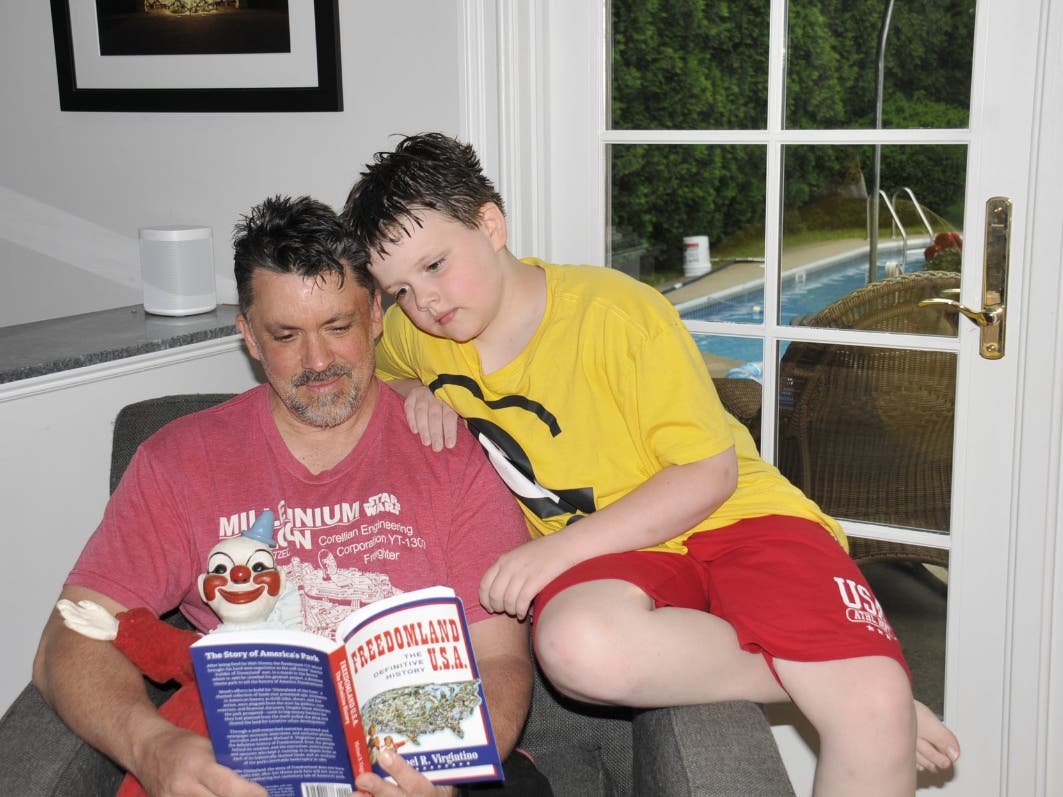 Steve and Spencer, Claude Kirchner’s grandson and great-grandson, respectively, read about Freedomland with Clownie.