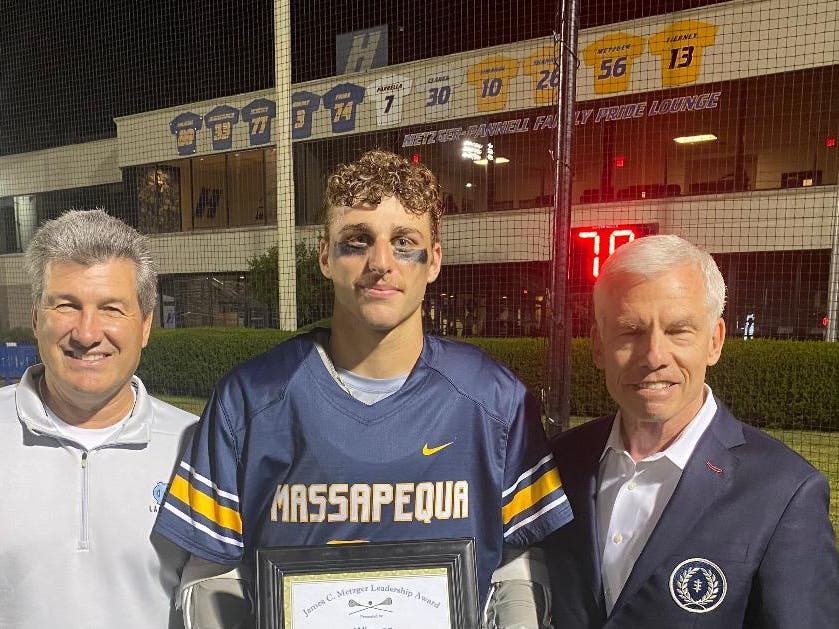 Tyler Byrnes of Massapequa High School received the 2026 James C. Metzger Lacrosse Leadership Award from Long Island lacrosse stars Vincent J. Sombrotto, left, and James C. Metzger. 