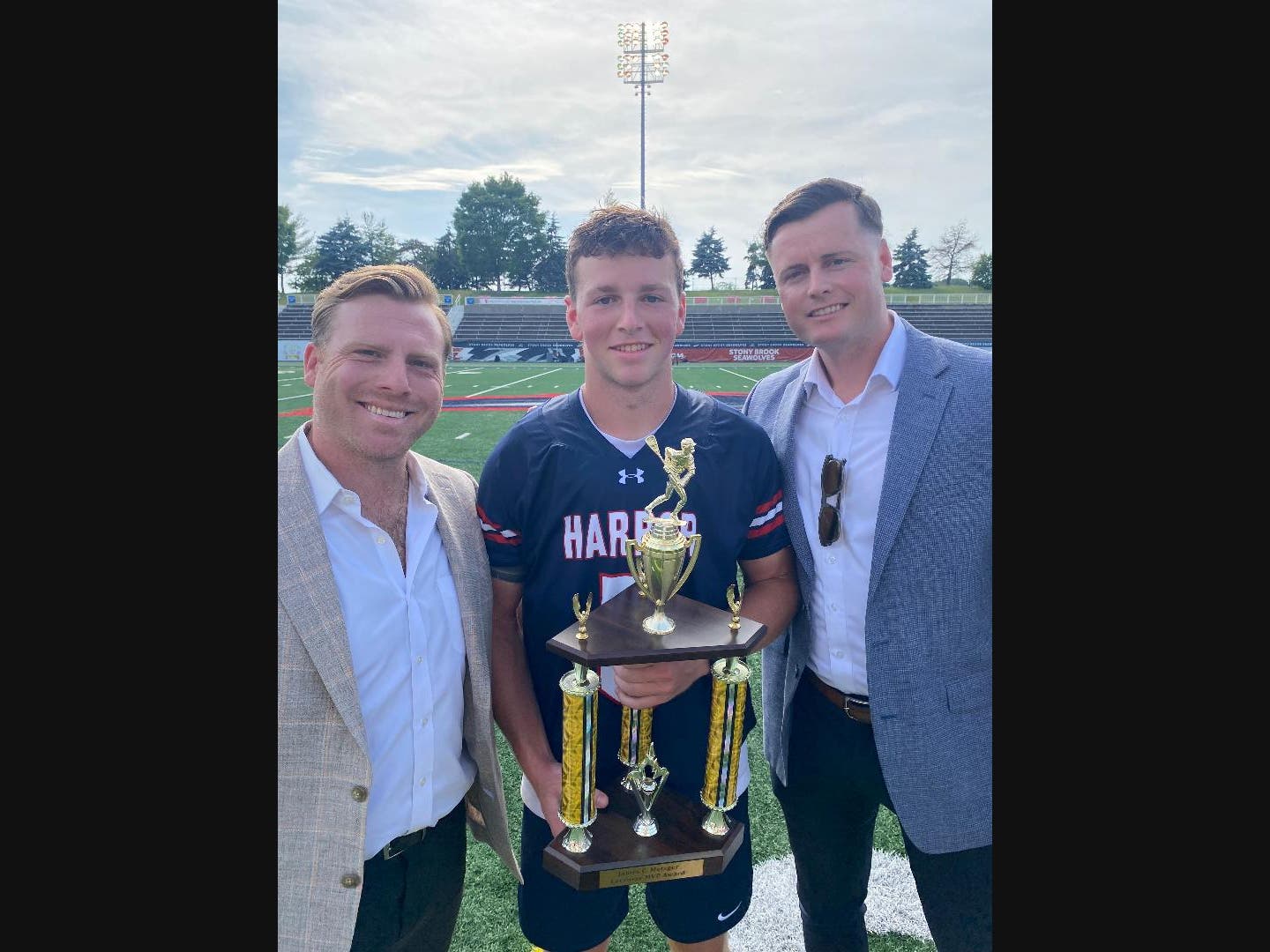 Senior co-captain midfielder/attackman Dylan Reilly of Cold Spring Harbor High School received the James C. Metzger MVP Award from Long Island lacrosse all-stars and All-Americans James Pannell and Jack Concorran at Class D 2026 Boys Championships.