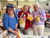 Members of Polly Cooper, DAR wrap juice boxes to prepare them for shipping