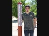 Joseph Keehn takes time to pose next to the peace pole he constructed in 2006 as an Eagle Scout project. The pole was refurbished and reinstalled in the new "playground for all."