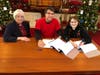 First Church Moderator Heidi Palmer (right) signs the contract. Robert Botelho (center), Senior Pastor Rev. Dr. Pat Kriss (left).