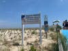 A new sign was unveiled, dedicating the beach in honor of Keith Pinto, who died protecting it.