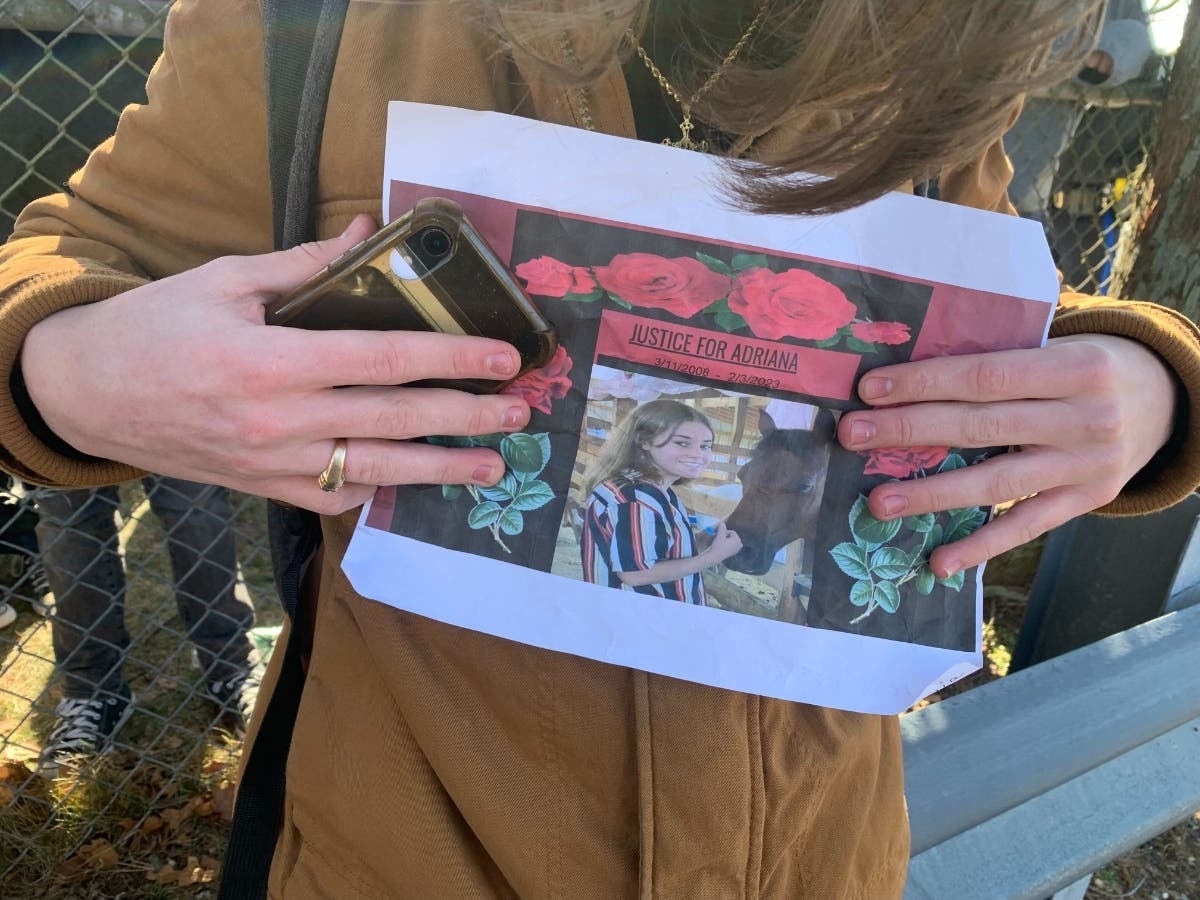 A friend holds a sign at Wednesday's protest, calling for justice for Adriana.