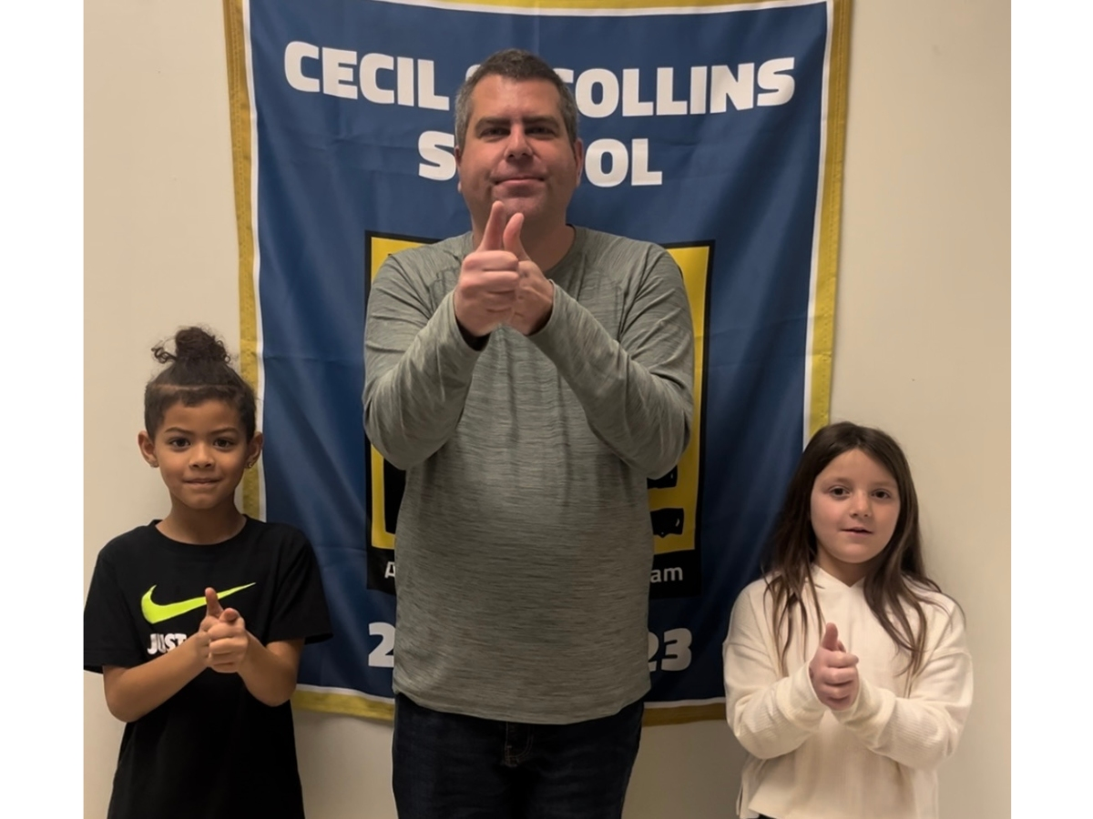 Anthony DeFranco (Center) demonstrating the sign for “Leadership” with Cecil S. Collins students Nehemiah Rodriguez (Left) and Peyton Augustine (Right). 