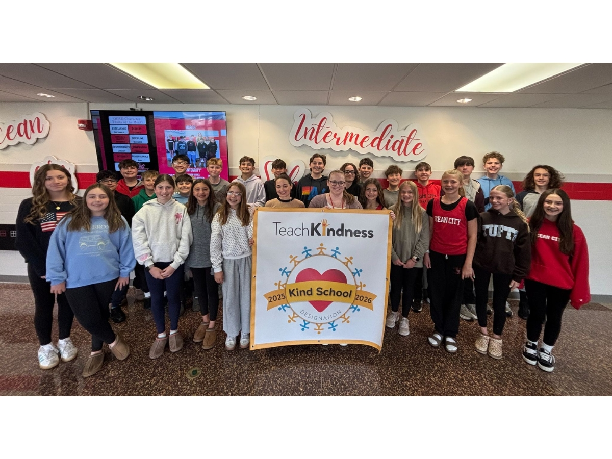 School Counselor Kara Uhrich and Student Assistance Counselor Eileen Conover are pictured with sixth- and seventh-grade students, holding the 2026 Kind School banner.
