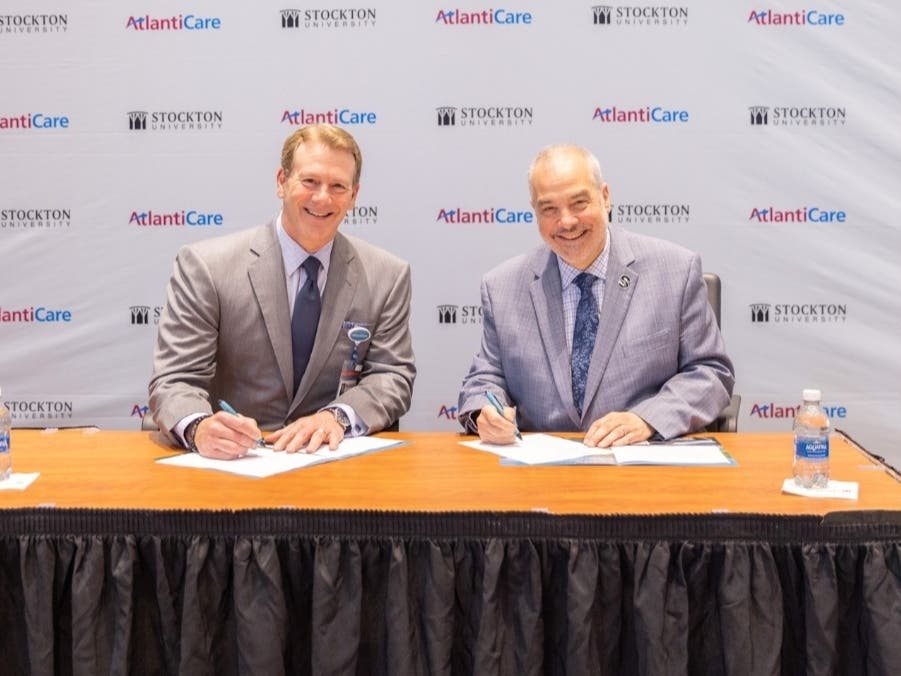 From left, Michael Charlton, president and CEO of AtlantiCare, and Stockton University President Joe Bertolino sign a new strategic alliance to establish the Stockton-AtlantiCare College of Community Health on May 7 at the university’s Galloway campus. 