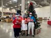 Participants in St. Coletta’s Community Day Services program join Recreational Therapist Stephanie Wingo under the tree to open a few presents from the Rotary Club of Orland Park.
