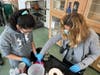 Transition Town teacher Leslie Chowaniec shows a student how to make bite-sized pieces of food for the cats at NAWS Humane Society in Mokena.