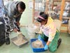 Aaron and Victoria clean two litter boxes during a recent visit to NAWS Humane Society in Mokena.