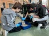 Transition Town student Jose (right) shows a classmate how to clean a litter box at NAWS Humane Society in Mokena.