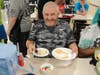 A participant in St. Coletta's Community Day Services program enjoys a slice of cake and homemade pizzelle with his ice cream sundae on July 25.