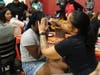 Patrice Billups, a behavior specialist at St. Coletta’s of Illinois, paints colorful butterfly wings around the eyes of a Kennedy School student.