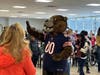 Staley Da Bear greets students and staff with a high five as he enters the room.