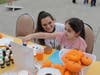 Kennedy School Culinary Arts Supervisor/Instructor Amy Quinn looks on proudly as a student decorates a mini pumpkin with paint, embracing creativity during St. Coletta’s Fall Fest.