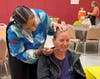 St. Coletta's CEO Heather Benedick embraces the Fall Fest spirit as Training Specialist/DSP Patrice Billups paints a cheerful candy corn on her cheek, showcasing the fun and festive atmosphere of the celebration.