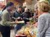 Training Specialist Shaleka Wilkins lends a helping hand as Kevin C., a participant in St. Coletta's Community Day Services program, fills his plate with Thanksgiving favorites.