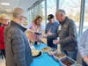 Volunteers add a finishing touch of chocolate, caramel and colorful sprinkles as participants enjoy custom-made sundaes at the ice cream social.