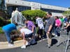 Participants gently place flowers at the base of the statue of Mary during St. Coletta’s May Crowning ceremony, honoring a cherished tradition of love and devotion.