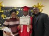 Graduate Keith shares a proud moment with his mom and dad as they pose together for a photo on his special day at Kennedy School.