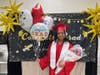 Proud graduate Brianna poses with a big smile after the ceremony, holding balloons and flowers lovingly gifted by her parents.