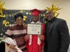 Graduate Keith shares a proud moment with his mom and dad as they pose together for a photo on his special day at Kennedy School.