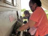 Deareo and Ronna, participants in St. Coletta’s adult day program, work together stuffing hay into the goat feeder at Navarro Farm. Their teamwork and care help build life skills and a strong sense of community.