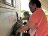 Deareo and Ronna, participants in St. Coletta’s adult day program, work together stuffing hay into the goat feeder at Navarro Farm. Their teamwork and care help build life skills and a strong sense of community.