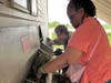Deareo and Ronna, participants in St. Coletta’s adult day program, work together stuffing hay into the goat feeder at Navarro Farm. Their teamwork and care help build life skills and a strong sense of community.