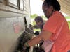 Deareo and Ronna, participants in St. Coletta’s adult day program, work together stuffing hay into the goat feeder at Navarro Farm. Their teamwork and care help build life skills and a strong sense of community.