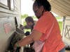 Deareo and Ronna, participants in St. Coletta’s adult day program, work together stuffing hay into the goat feeder at Navarro Farm. Their teamwork and care help build life skills and a strong sense of community.