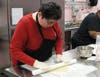 Mary rolls out the dough using wooden dowels to determine the perfect thickness.