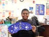 Beaming with pride, a student shows off his vibrant artwork inspired by Hebru Brantley.