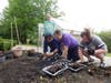 Clinical Therapist David Saavedra works alongside participants as they carefully plant vegetable seeds near the greenhouse. 
