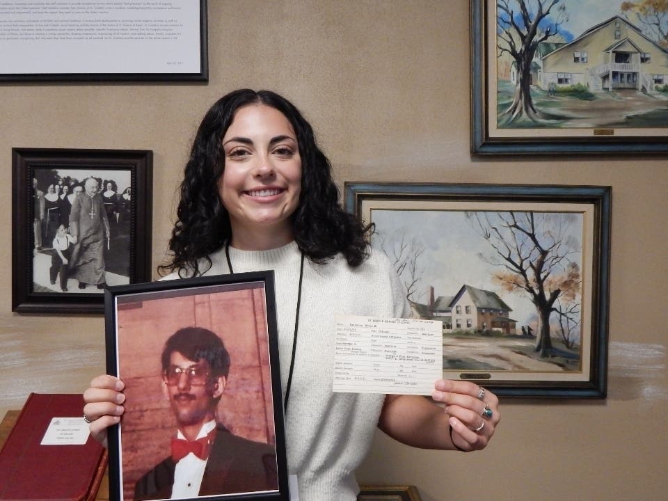 Meghan Martewicz, a clinical therapist at St. Coletta's of Illinois, stands with a photograph of her late uncle, Brian, and his original Kennedy School registration card after discovering that he attended the organization more than 50 years ago.