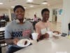 Two students get ready to enjoy their cake and ice cream sundaes.