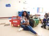 Teacher Tasheka Klimczak takes a moment to celebrate two of the standout creations from Kennedy School’s first-ever Box Car Parade – a Lightning McQueen race car and a Jurassic Park Jeep. 