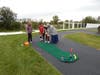 Special education teacher Maria Demakis helps a student line up a putt during Fall Fest as a volunteer from All Saints Lutheran Church assists.