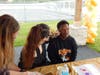 Mental Health Professional Richanne Matthews adds a colorful touch of face paint to a student during Fall Fest.