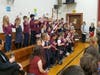 Kindergarten, Grade 1 and Grade 2 pupils lead the singing of 'You’re a Grand Old Flag' to veterans and responders earlier this month.
