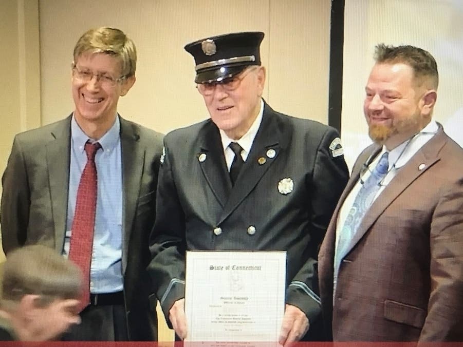 Veteran Farmington Fire Department firefighter Richard 'Dick' Glanovsky, center, is flanked by state Rep. Mike DeMicco, D-Farmington, left, and Farmington Councilman Joe Capodiferro, right, as Glanovsky was honored as 'firefighter of the year' Dec. 13.