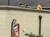 Firefighters with the Vernon Volunteer Fire Department work on the roof at a local Dunkin' shop Friday morning to deal with an HVAC unit fire on top of the roof.