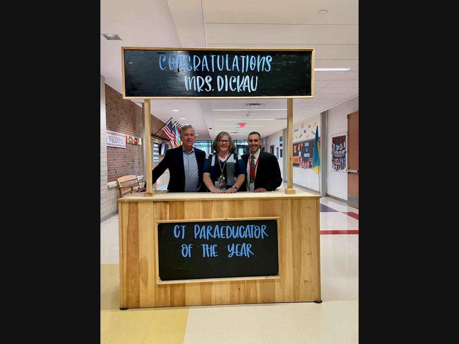 Dawn Dickau, center, was named the state's 2023-24 paraeducator of the year in a surprise ceremony Friday morning. At left is Gov. Ned Lamont and at right is Christopher Palmieri, principal of Joseph A. DePaolo Middle School in Southington.