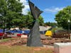 Workers scramble Wednesday, May 29, to erect a statue featuring the tail of the beloved 'Conny the Whale' in West Hartford.