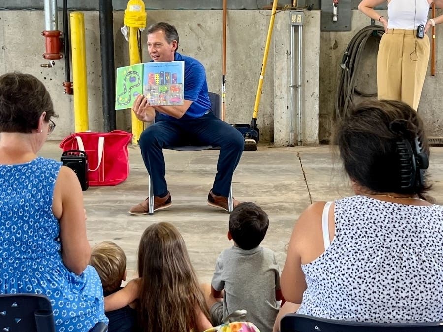 Simsbury Department of Public Works Director Tom Roy took time out from fixing roads and sidewalks Wednesday to read to local children, as the DPW hosted the Simsbury Public Library's regular Story Town event.